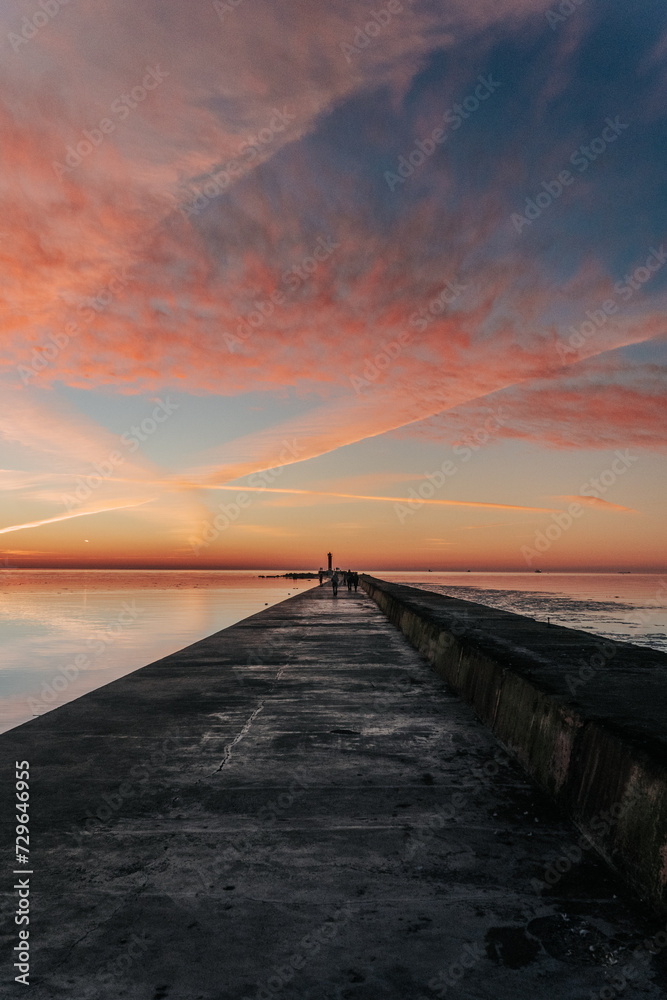 sunset in the sea and a long jetty