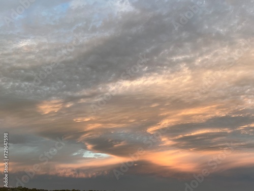 Soft cloudscape of pink, orange and grey at sunset.