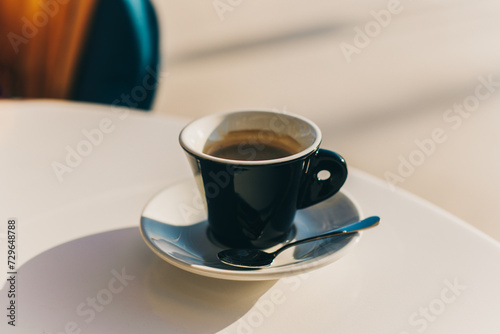 Cup of black coffee on a table in a street cafe.