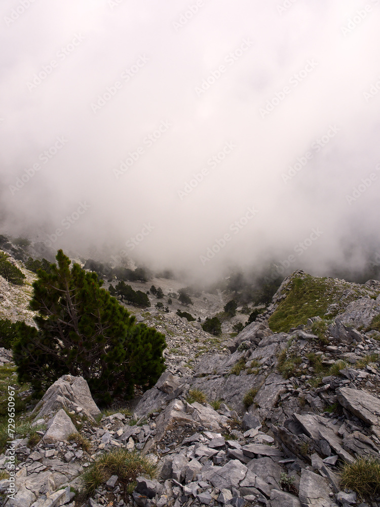 Mountain rocky hillside covered in clouds. Copy space available. 
