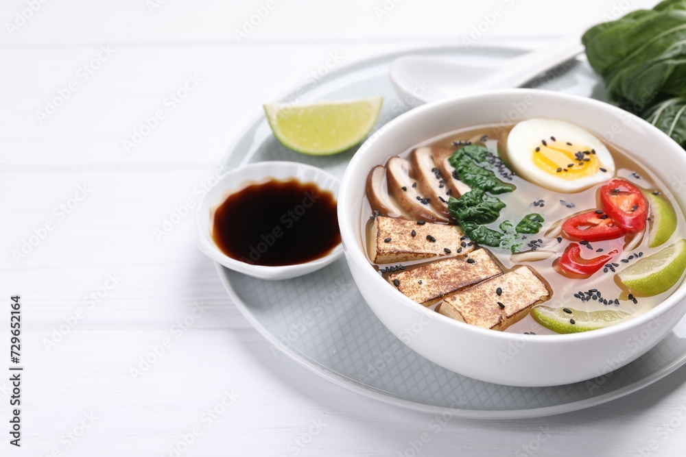 Delicious vegetarian ramen in bowl and soy sauce on white table. Space for text Delicious vegetarian ramen in bowl and soy sauce on white table. Space for text