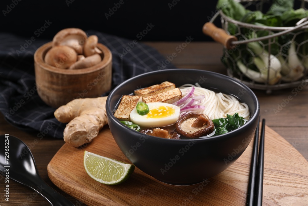Delicious vegetarian ramen in bowl and products on wooden table Delicious vegetarian ramen in bowl and products on wooden table