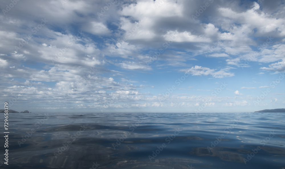 Background of white clouds and their reflection in open sea, with space for text