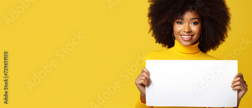 happy woman looking at a camera holding a white sign on a yellow background - copy space mockup