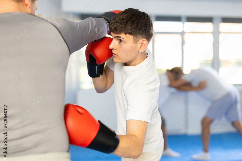Two athlete men in sportswear practicing boxing sparring in the hall