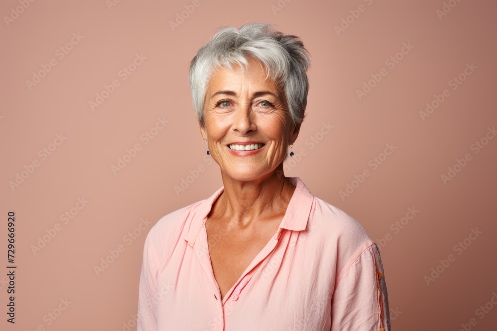 Portrait of a happy senior woman smiling at camera over pink background Portrait of a happy senior woman smiling at camera over pink background