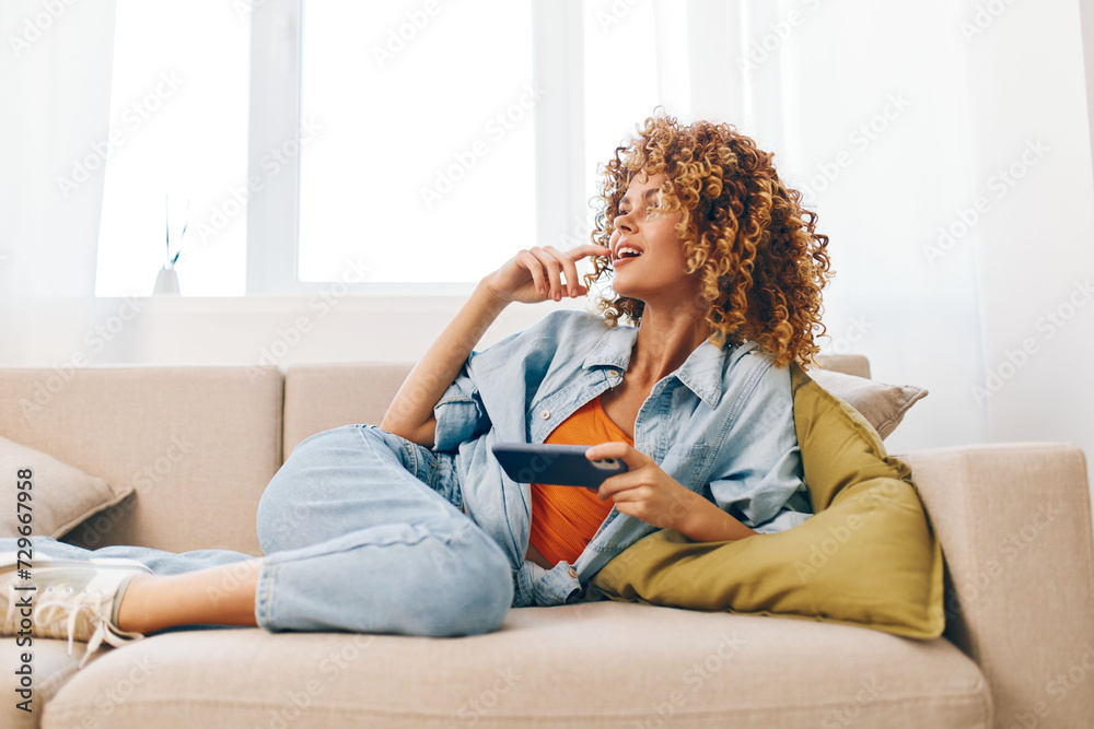 Smiling Woman Holding Mobile Phone, Enjoying Leisure Time on Cozy Sofa at Home. Smiling Woman Holding Mobile Phone, Enjoying Leisure Time on Cozy Sofa at Home.