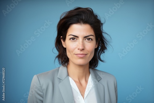 Closeup portrait of beautiful business woman, isolated on blue background.