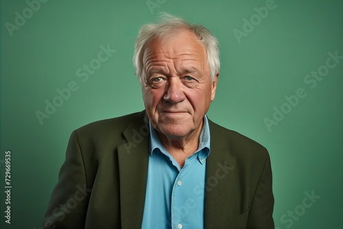 Portrait of a senior man on a green background. Studio shot.