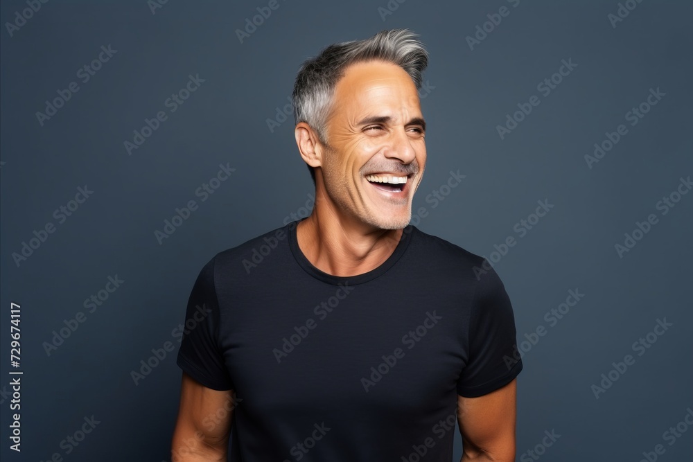 Portrait of happy mature man in black t-shirt on grey background
