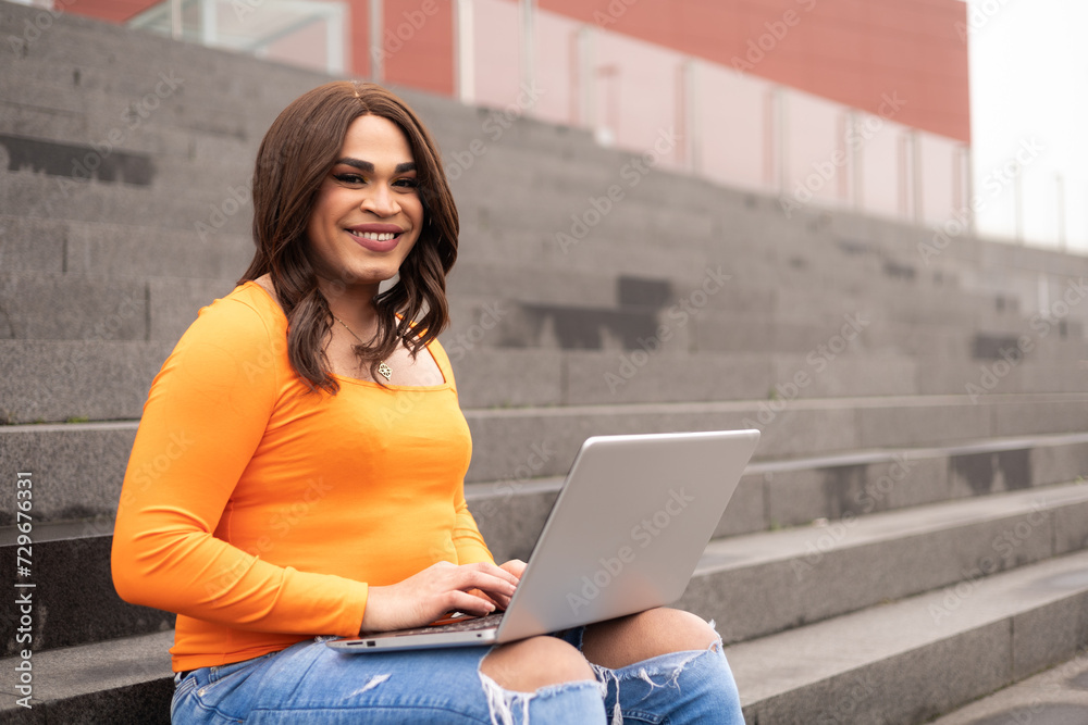 Close-up portrait of trans latin woman using laptop in campus stairs. Trans inclusion concept. Close-up portrait of trans latin woman using laptop in campus stairs. Trans inclusion concept.