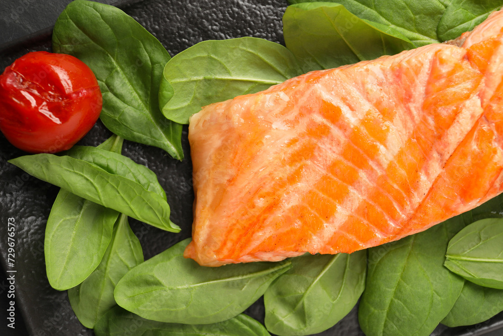 Tasty grilled salmon with tomato and spinach on table, top view Tasty grilled salmon with tomato and spinach on table, top view