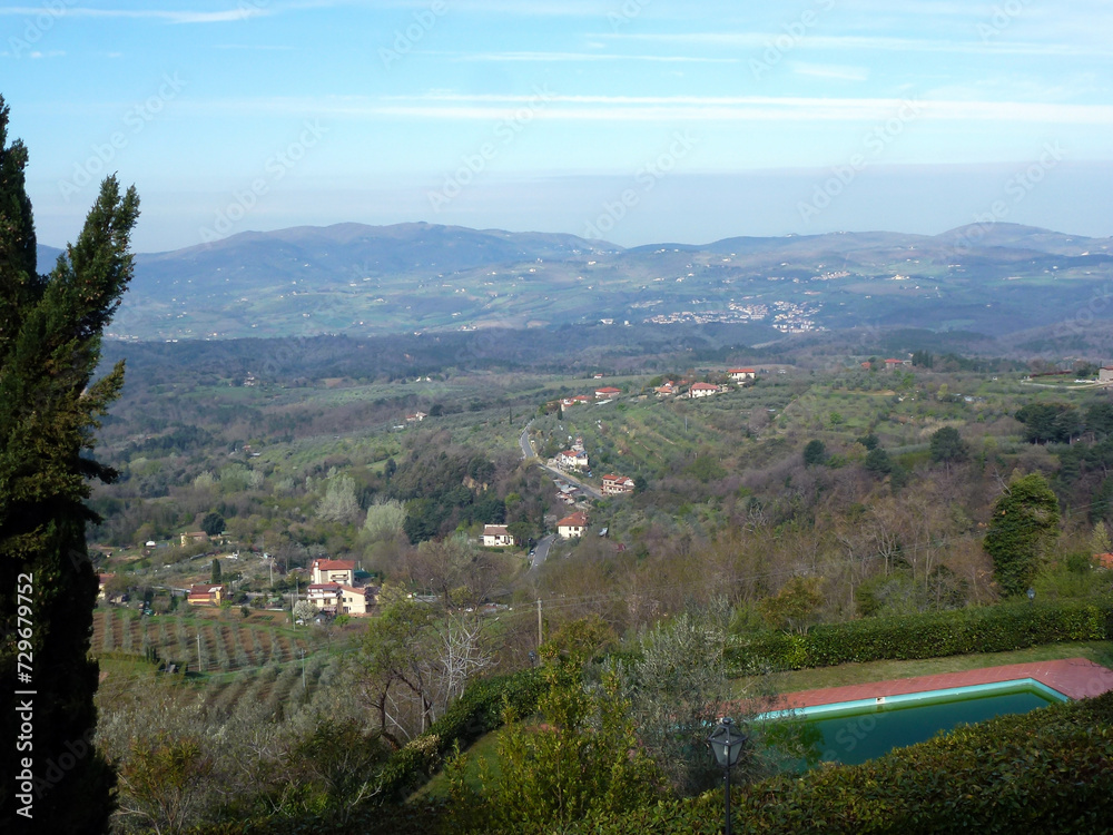 Naklejka premium In the foreground is the estate's swimming pool. In the background is a valley with hotels, cottages and mountains in the distance
