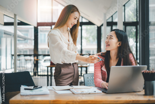 Business team concept, Two colleagues sharing a light-hearted moment during a productive workday in a sunny, contemporary office setting.