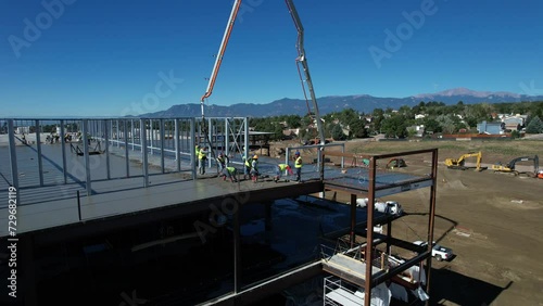 Aerial view of construction workers pouring concrete on a commercial building