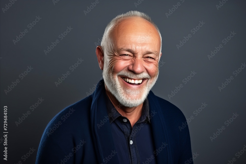 Portrait of a happy senior man laughing against a grey background. Portrait of a happy senior man laughing against a grey background.