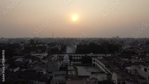 Aerial video over buildings in the city of Ludhiana, India at sunset