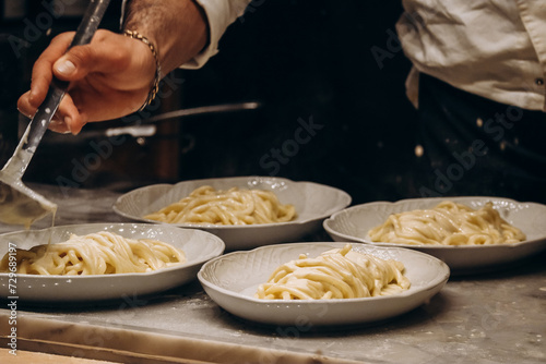 Fototapeta Naklejka Na Ścianę i Meble -  Italian chef preparing spaghetti with sauce