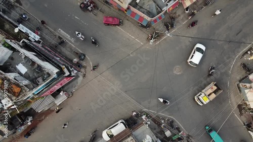 Aerial video of cars and tuk tuks driving through an intersection in the city of Ludhiana, India