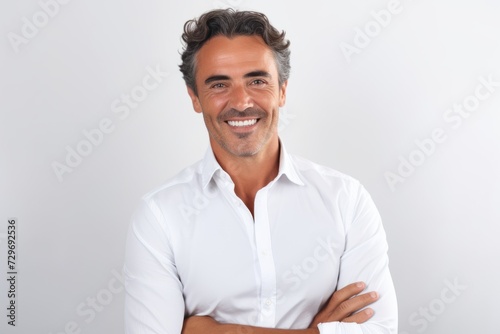 Portrait of a handsome mature man standing with arms crossed against white background