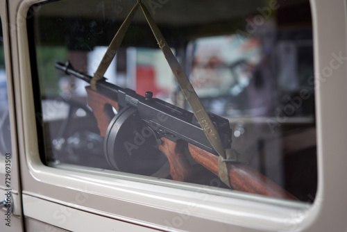 Closeup of RPD machine gun hanging inside car window. Powerful firearm against the backdrop of the car interior. photo