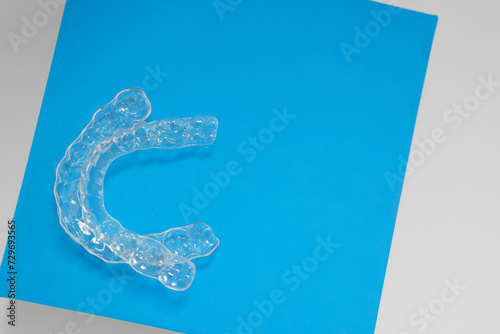 Transparent dental aligners on color background, flat lay. Space for text