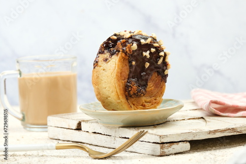 New York Roll, Round Croissant or Cromboloni, Croissant Bomboloni. Filled and Covered with Chocolate. and Nut photo