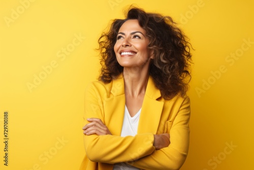 Portrait of a smiling young woman in yellow jacket over yellow background