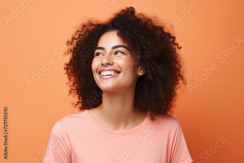 Portrait of a happy young african american woman on orange background