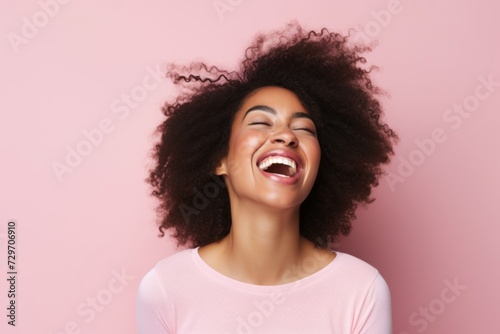 Happy african american woman with long afro hairstyle on pink background