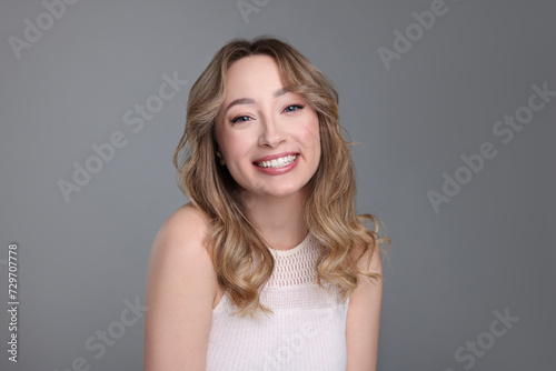 Portrait of smiling woman on grey background