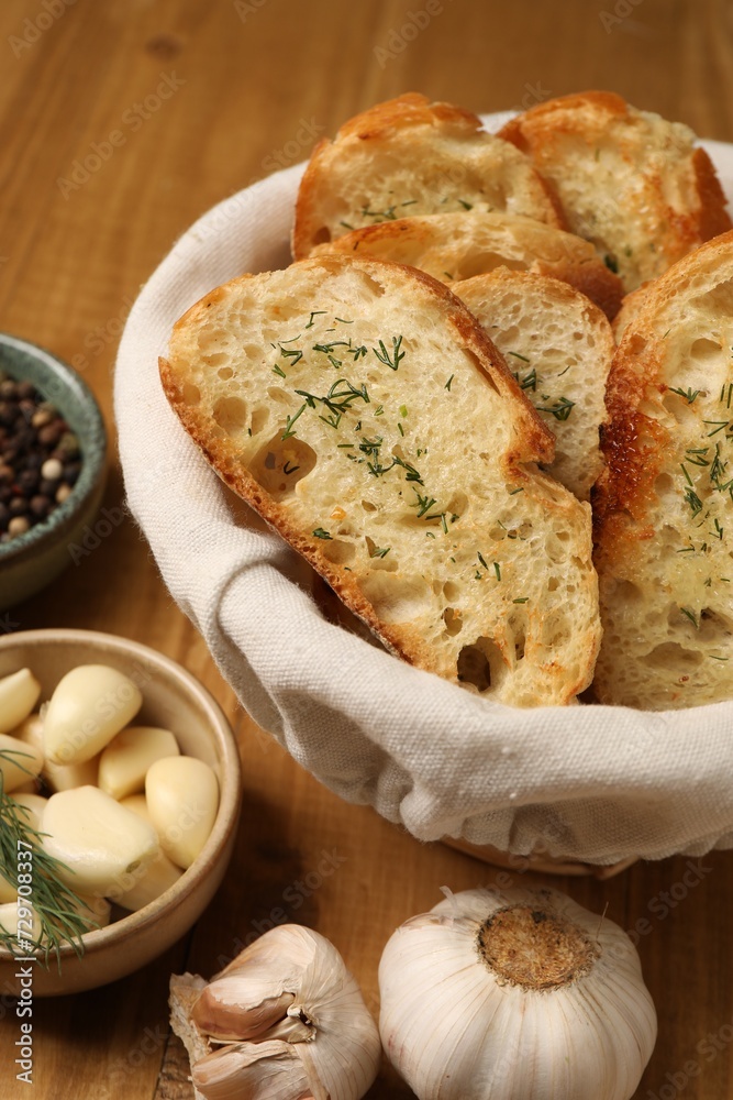 Tasty baguette with garlic and other spices on wooden table Tasty baguette with garlic and other spices on wooden table