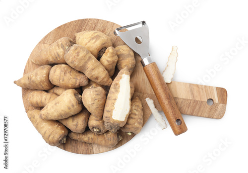 Tubers of turnip rooted chervil and peeler isolated on white, top view photo