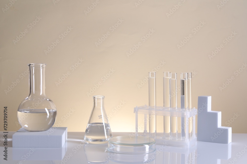 Laboratory analysis. Different glassware on table against beige background Laboratory analysis. Different glassware on table against beige background