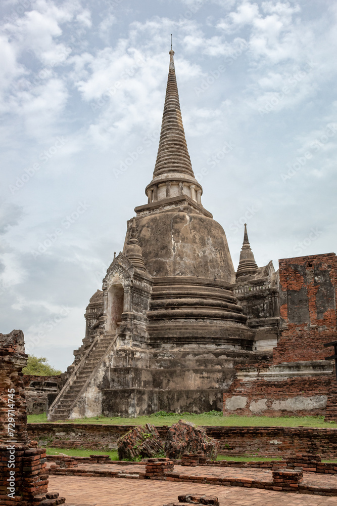 Traditional Thai stone pagoda building structure ruins at Wat Phra Si Sanphet temple in Ayutthaya Thailand historical park on a cloudy day