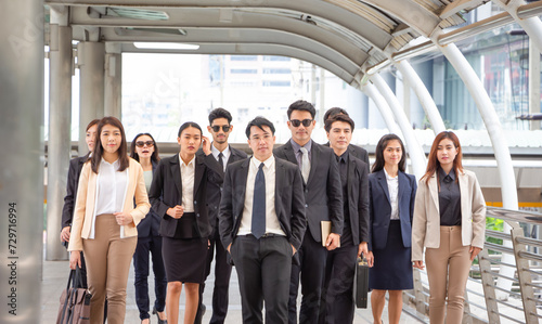 Group of happy young Asian business team, businesspeople walking the outdoor office together success teamwork for concepts