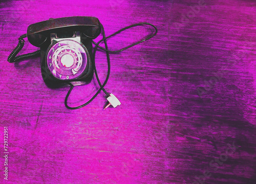 Teléfono antiguo con disco y cable sobre textura