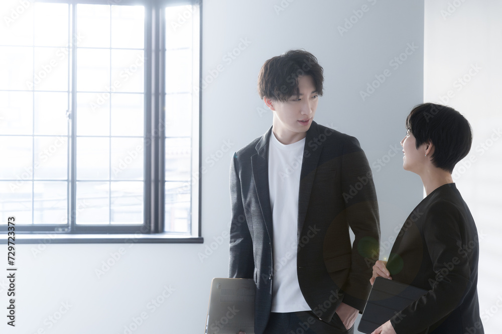 Smiling businesswoman and businessman with a computer having a meeting Smiling businesswoman and businessman with a computer having a meeting