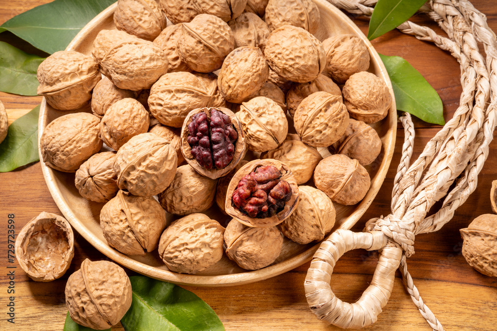 Red Walnuts in wooden bowl on wooden background, Walnuts kernels in wooden basket on wooden table. Red Walnuts in wooden bowl on wooden background, Walnuts kernels in wooden basket on wooden table.