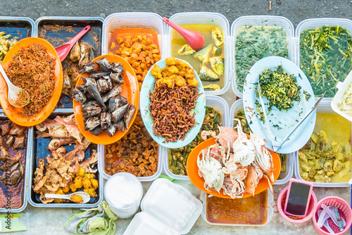 Variety of delicious Malaysian home cooked dishes sold at street market stall in Kota Kinabalu Sabah from top angle view. photo