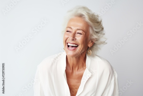 Portrait of a happy senior woman laughing isolated on white background.