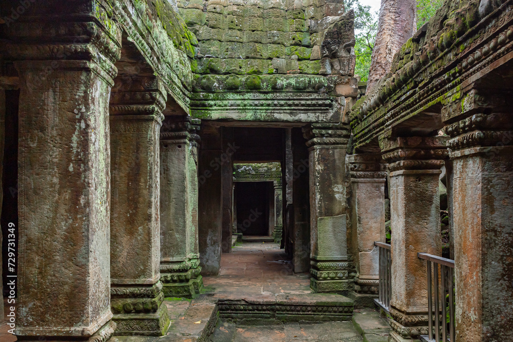 Green moss-covered stone building pillars at Ta Prohm Tomb Raider temple complex. Angkor Wat historical site, Siem Reap, Cambodia Green moss-covered stone building pillars at Ta Prohm Tomb Raider temple complex. Angkor Wat historical site, Siem Reap, Cambodia
