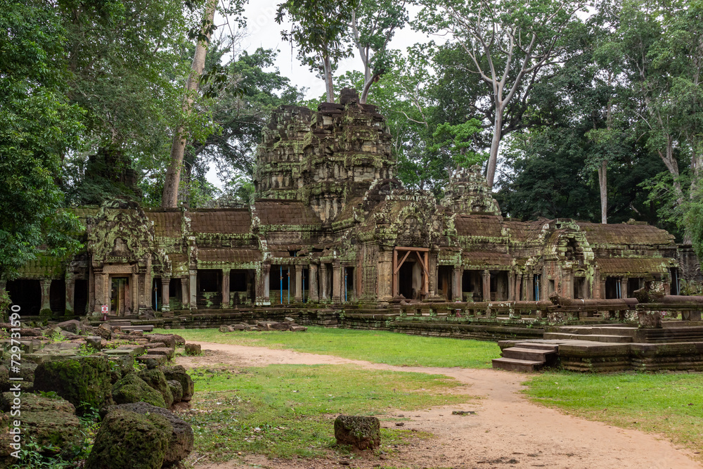 Moss-covered green stone building structure exterior and bricks at Ta Prohm Tomb Raider temple complex in the lush green forest. Angkor Wat historical site, Siem Reap, Cambodia