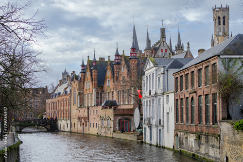 Beautiful city skyline of the village building architecture along a rozenhoedkaai Rosary Quay river canal reflection in Brugge Flanders Belgium on a cloudy day