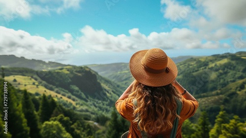 woman traveller holding hat and looking at a mountain