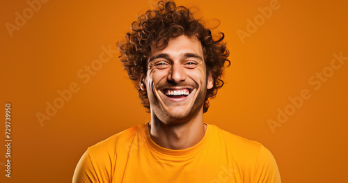 Man with Curly Hair in Orange Radiating Happiness © Dinaaf