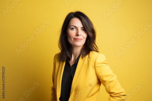 Portrait of a beautiful business woman in yellow jacket on yellow background © Iigo