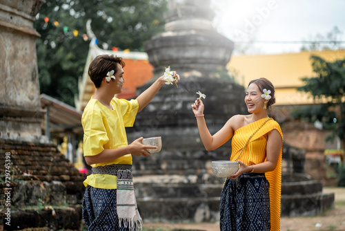 Photography Songkran Festival - Young Asians Wearing Thai Clothes Pose Happily Playing in the Water During Songkran Festival, Buddha Statue Bathing Ceremony During Songkran Festival, Splashing water