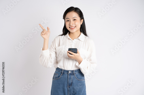 Portrait of young Asian businesswoman using phone on white background