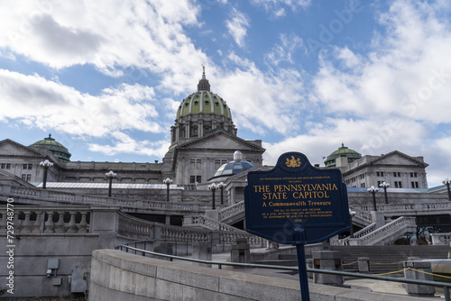 Clouds of the Pennsylvania State Capitol Building in Harrisburg with historic marker sign. 